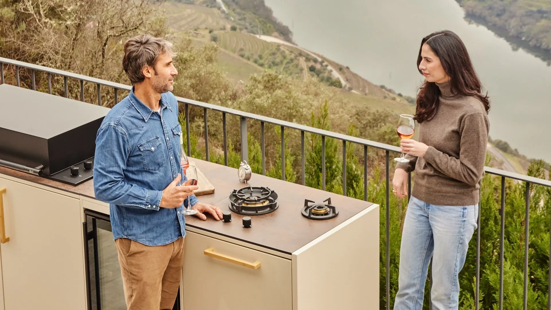 Convives autour d'une cuisine extérieure modulaire face à la vallée